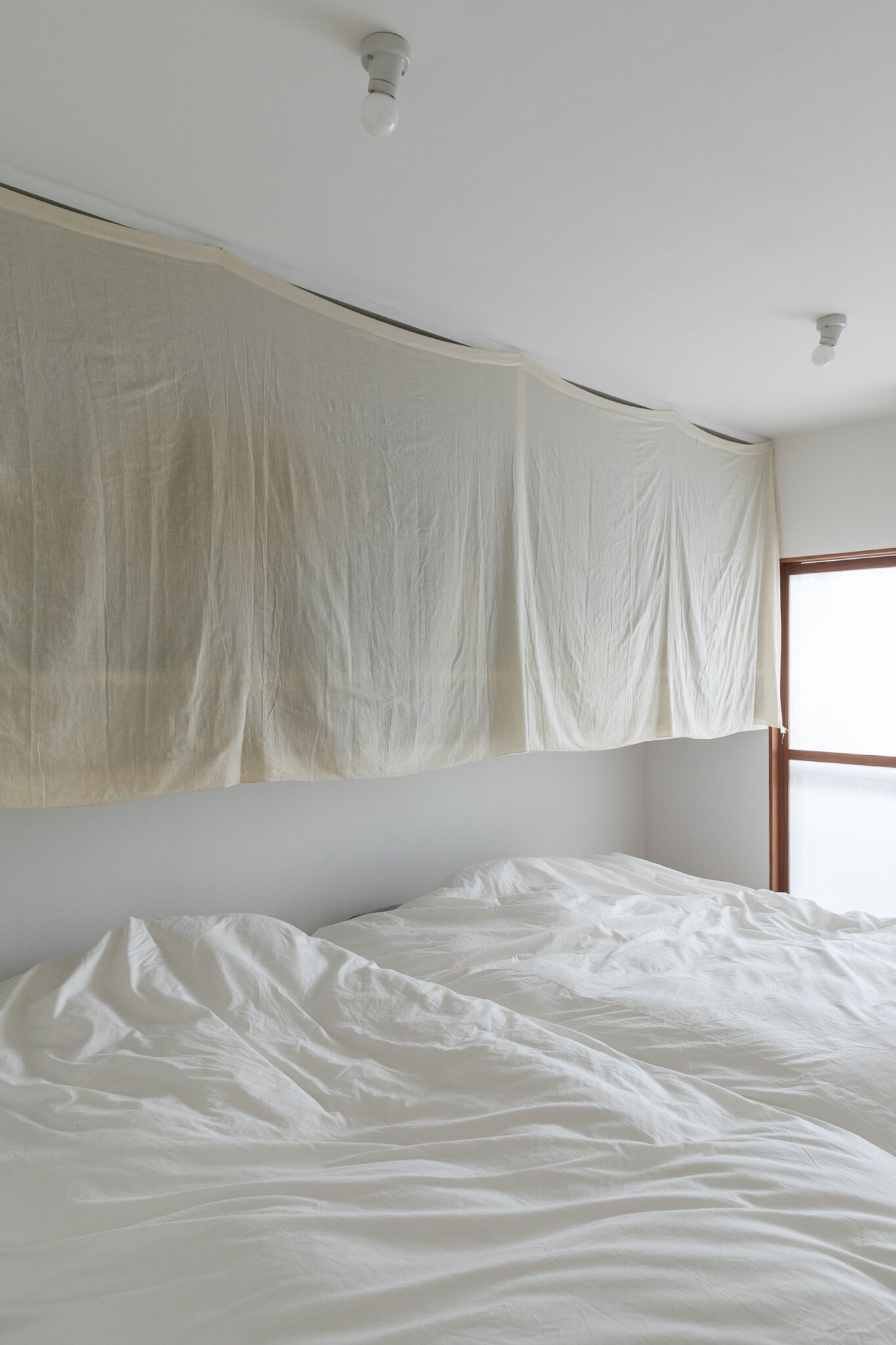 寝室の枕の上部に収納を設けた。「モノを厳選して、ここに家族3人分の洋服などを収納しています」