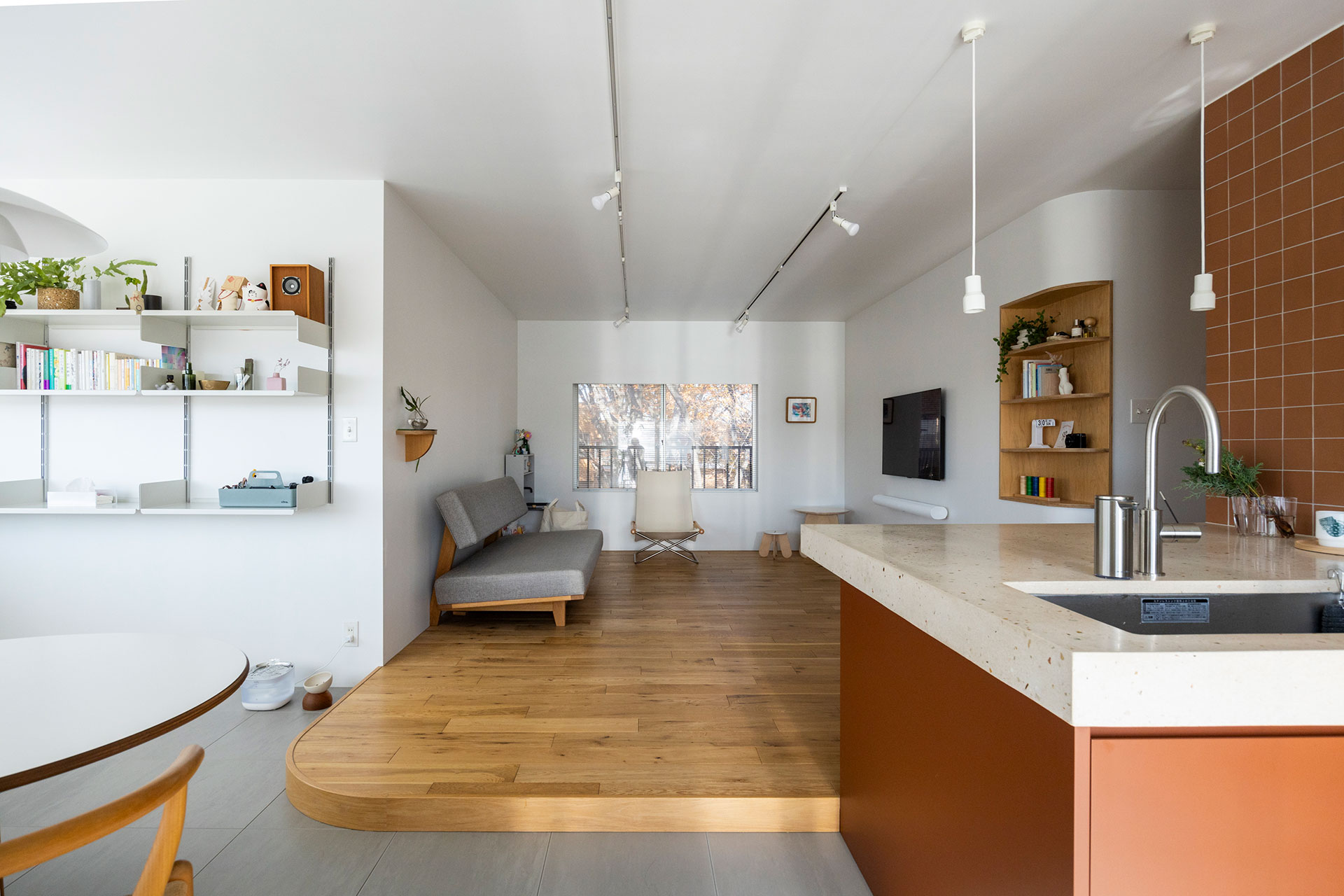 リビングの窓からは、ケヤキやキンモクセイの木が茂る共用広場がのぞめる。１段あげた床のコーナーに、Rの曲線をつけた。