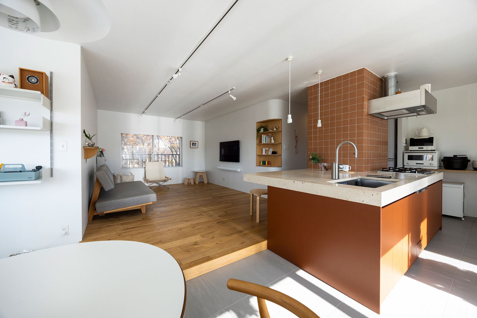 柱を活かしてL字型にアイランドキッチンを造作。下に収納を設け、柱よりワントーン濃い色で塗装した。