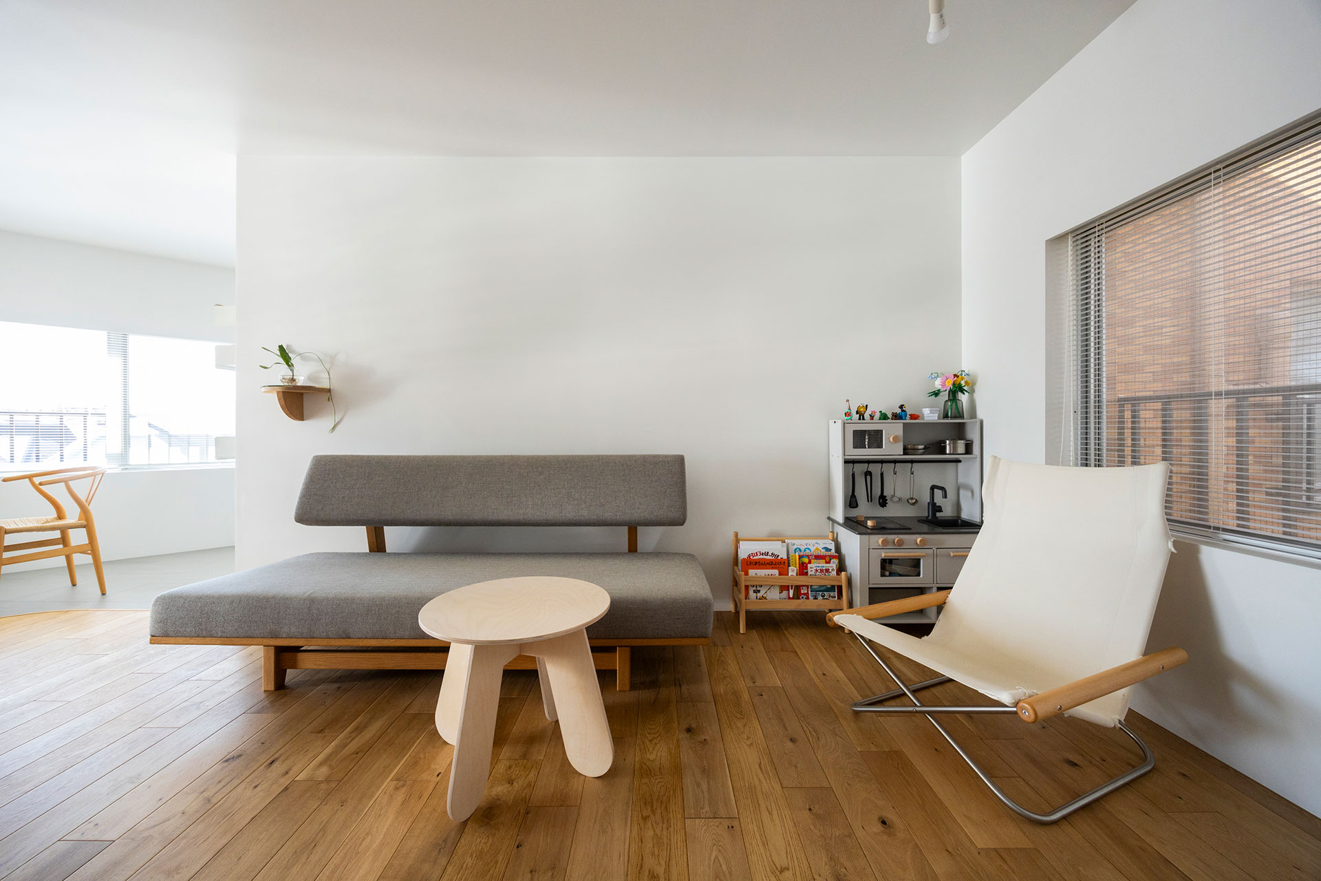 個室の仕切りを取ってリビングに。今は子供の遊び場となっている。ソファは高知のオリジナル家具店「FLAT FURNITURE」。子供用のテーブルは、ウクライナの木製家具ブランド「babai」。