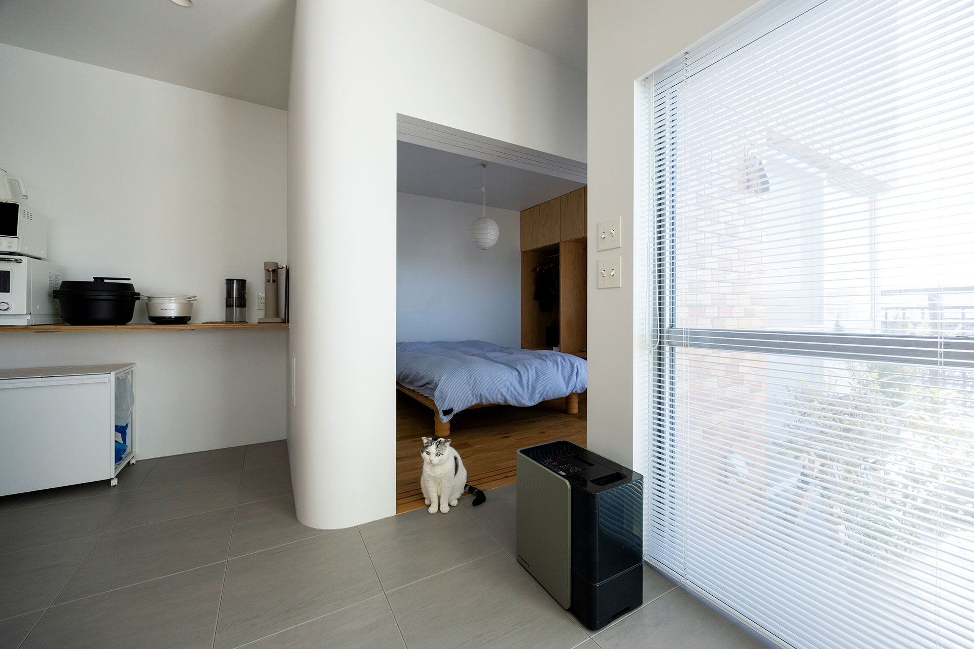 キッチンの奥にベッドールームが。仕切り壁にR加工を施している。