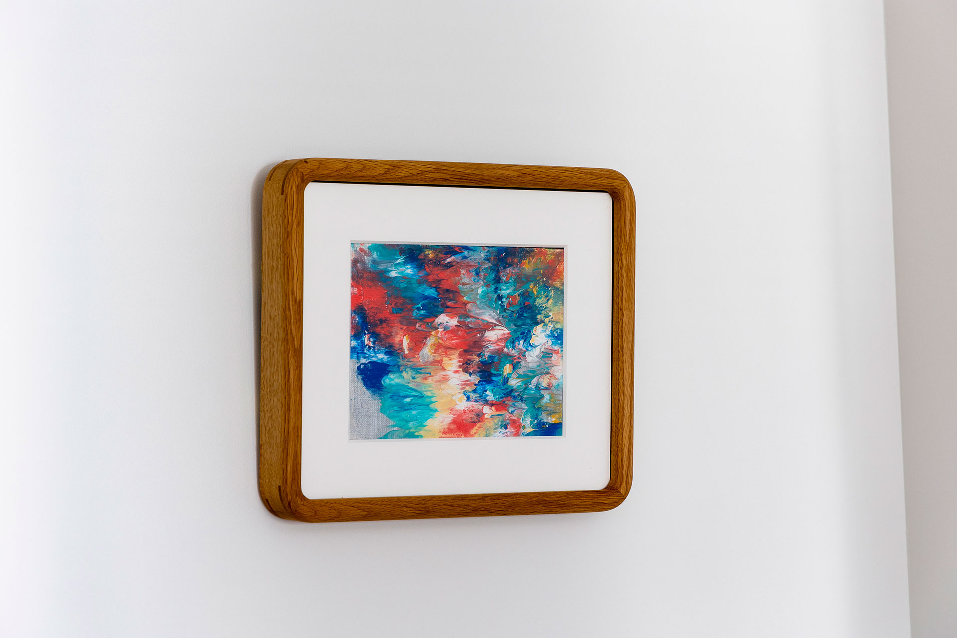 色彩が美しいアートは、なんと１歳のご長男作。コーナーにRを施した額縁をオーダーして額装した。