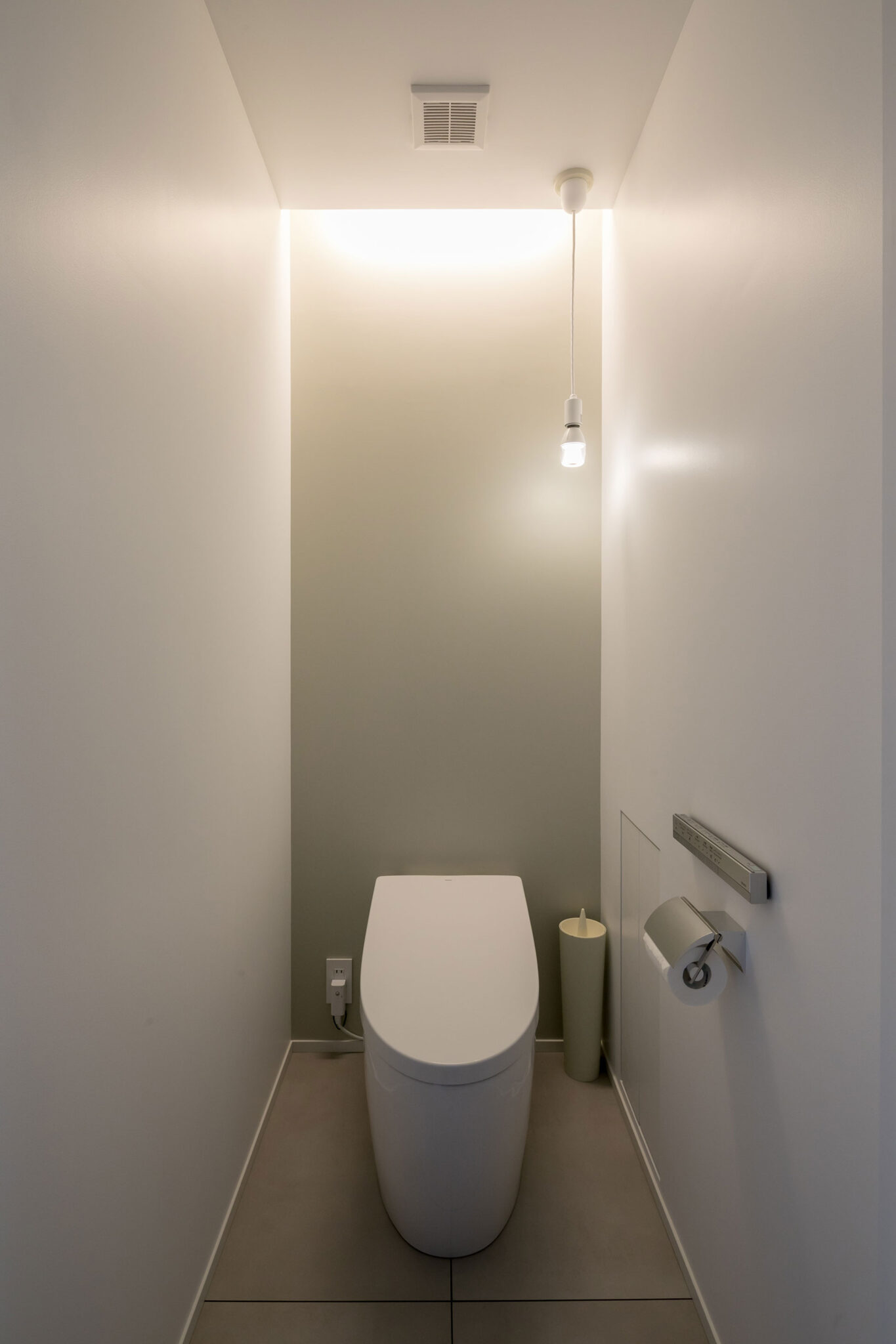 間接照明を設けたトイレ。右下壁面に収納扉が見える。