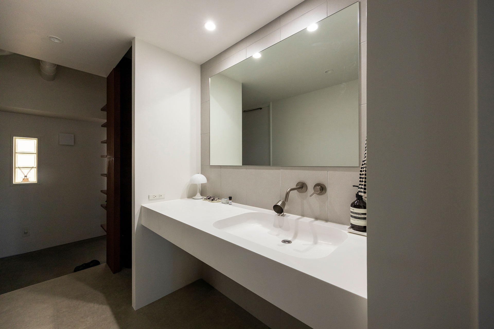 洗面台は、toolboxのシンプルな１枚の埋め込み型を採用。壁面には土間用の大判のタイルをあしらった。