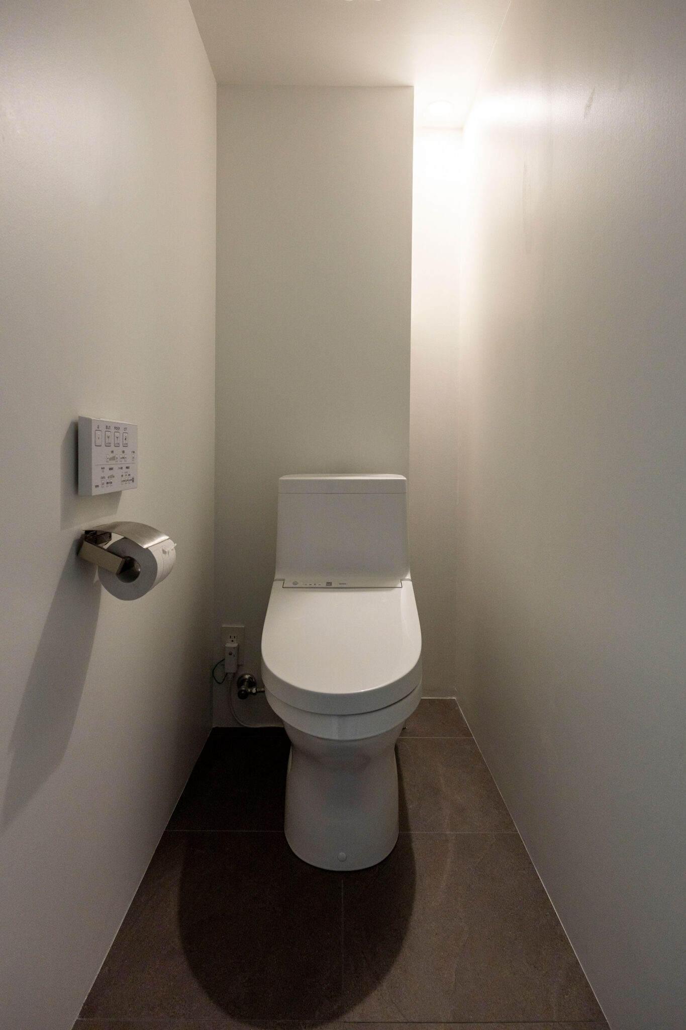 横から取り出せる収納棚で生活感を排除。ダウンライトは部屋中央ではなく棚の脇に設置し、落ち着きのある空間を演出。