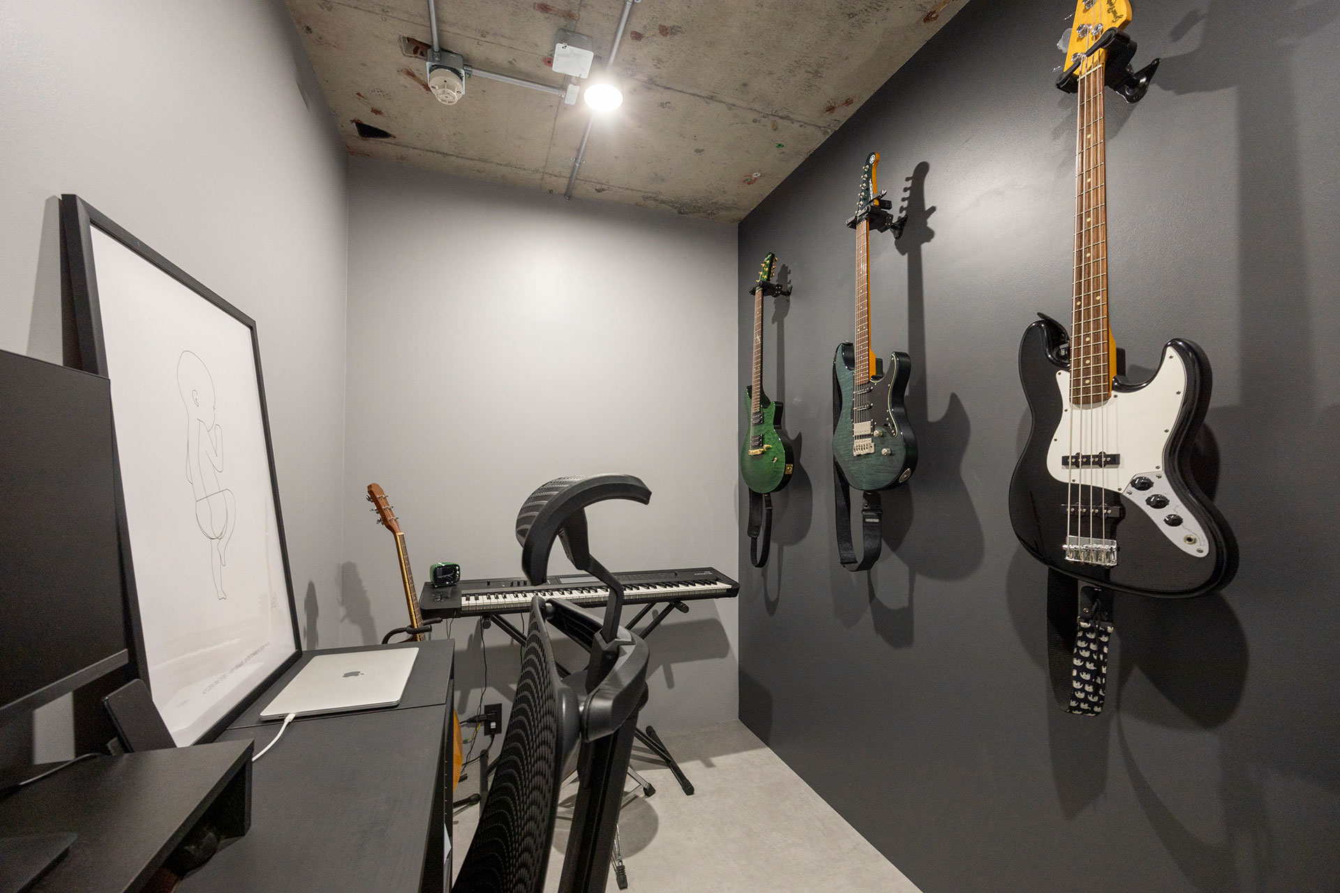 一面をダークグレーで塗装。ギターやベースが映える。