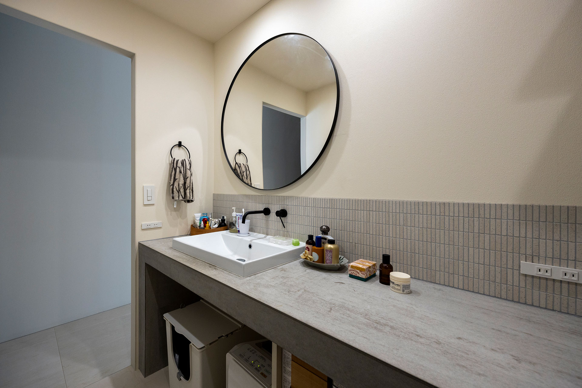 洗面台は、床材に使うフレキシブルボードで造作。モルタルに見えつつ、機能的でコストもカット。