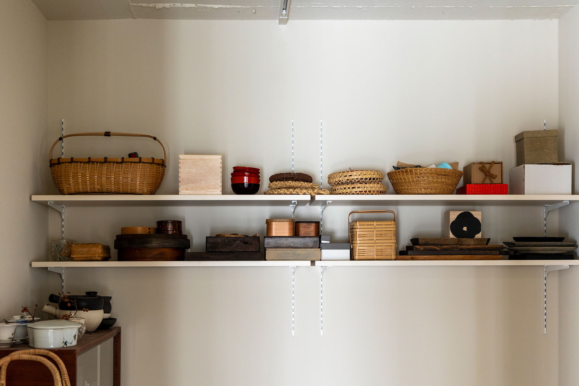 籐製品や木製のお弁当箱、漆のお椀など、見ているだけでも楽しいパントリーの棚。