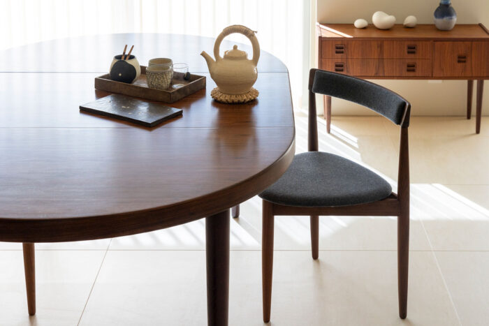 エクステンションできるカイ・クリスチャンセンのダイニングテーブル。3本脚のアンティークチェアはハンス・オルセン。テーブル上は、大切にしている十場あすかの急須など。