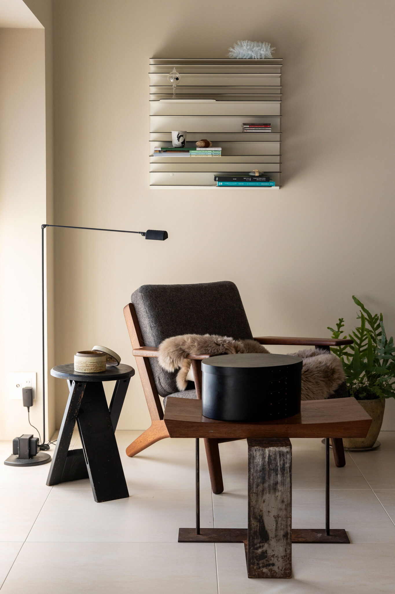 ハンス・J・ウェグナーのGE290 (1人掛けチェア) の手前は、ピエール・シャローのテーブル。個人輸入した壁のシェルフは、スペクトラムのペーパーバック。