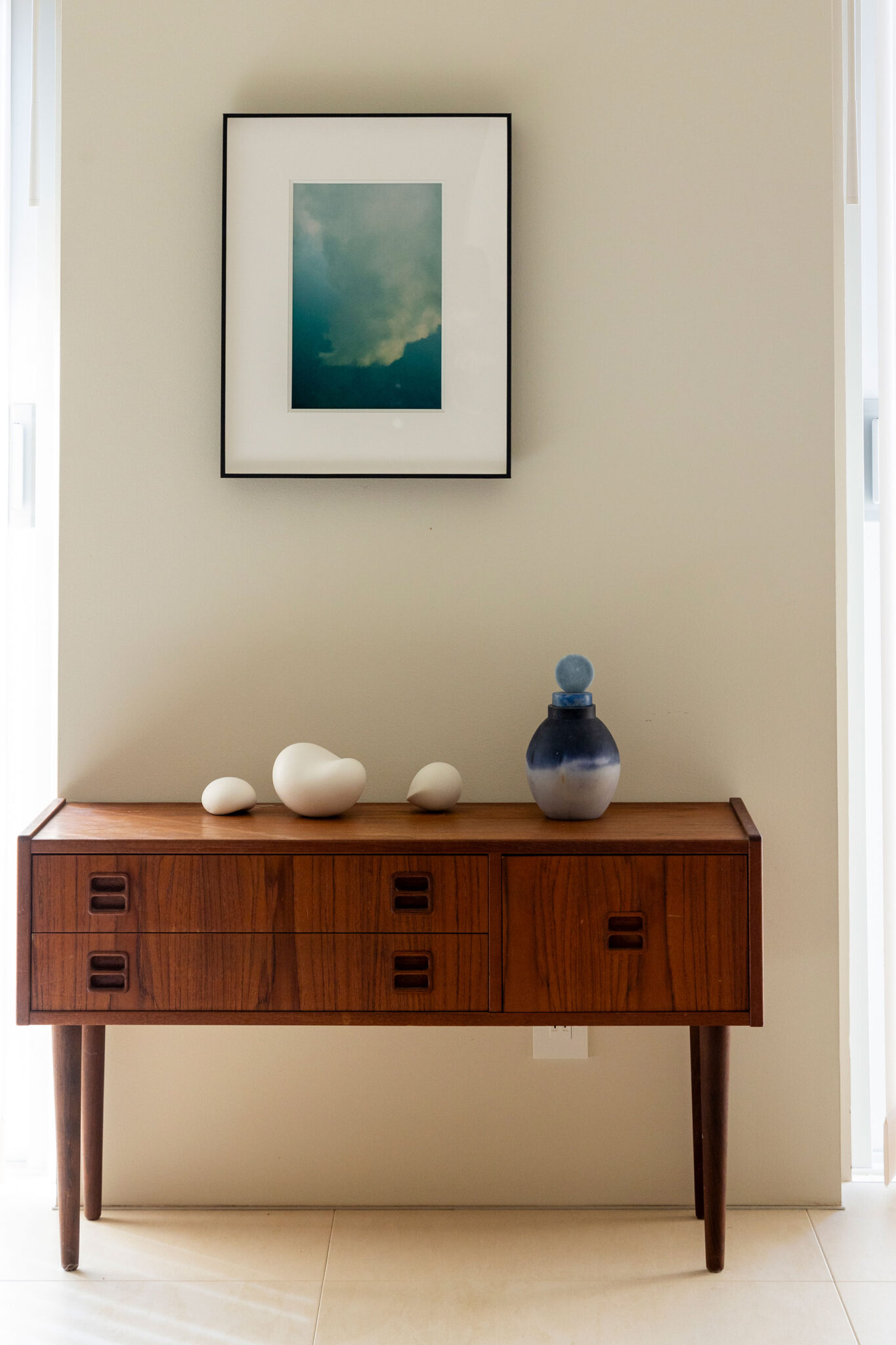 壁の額装はアーティストYUKI MORIOKAの作品。水面に映った雲を反転させたフォトグラフ。インスタグラムで発見して購入した。