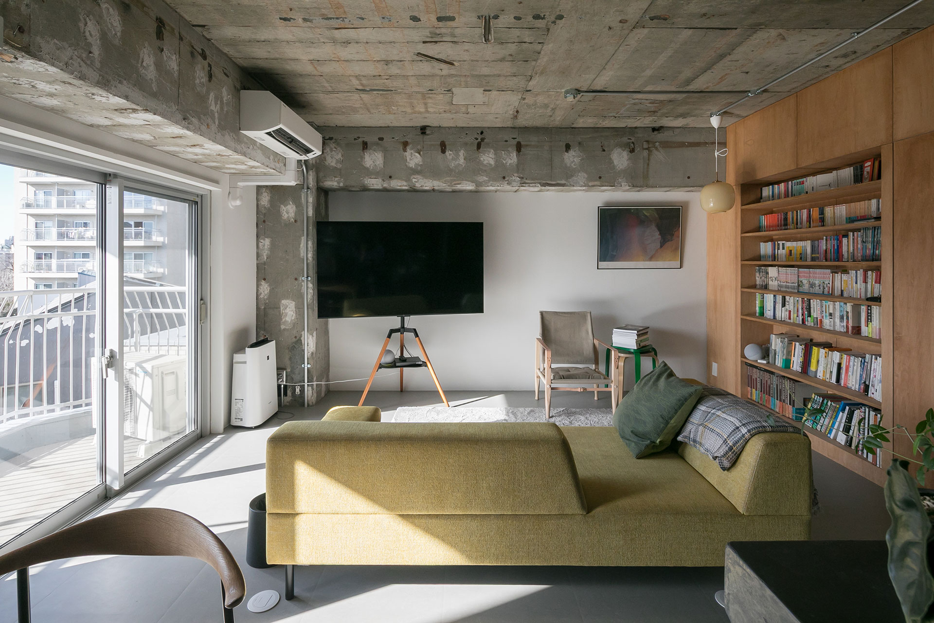 「空間を遮らない、背もたれの低いソファが良かったので、『フランネルソファ』でセミオーダーしました。汚れがつきづらいファブリックも気に入っています」。木製の脚のTV台はamazonで発見。