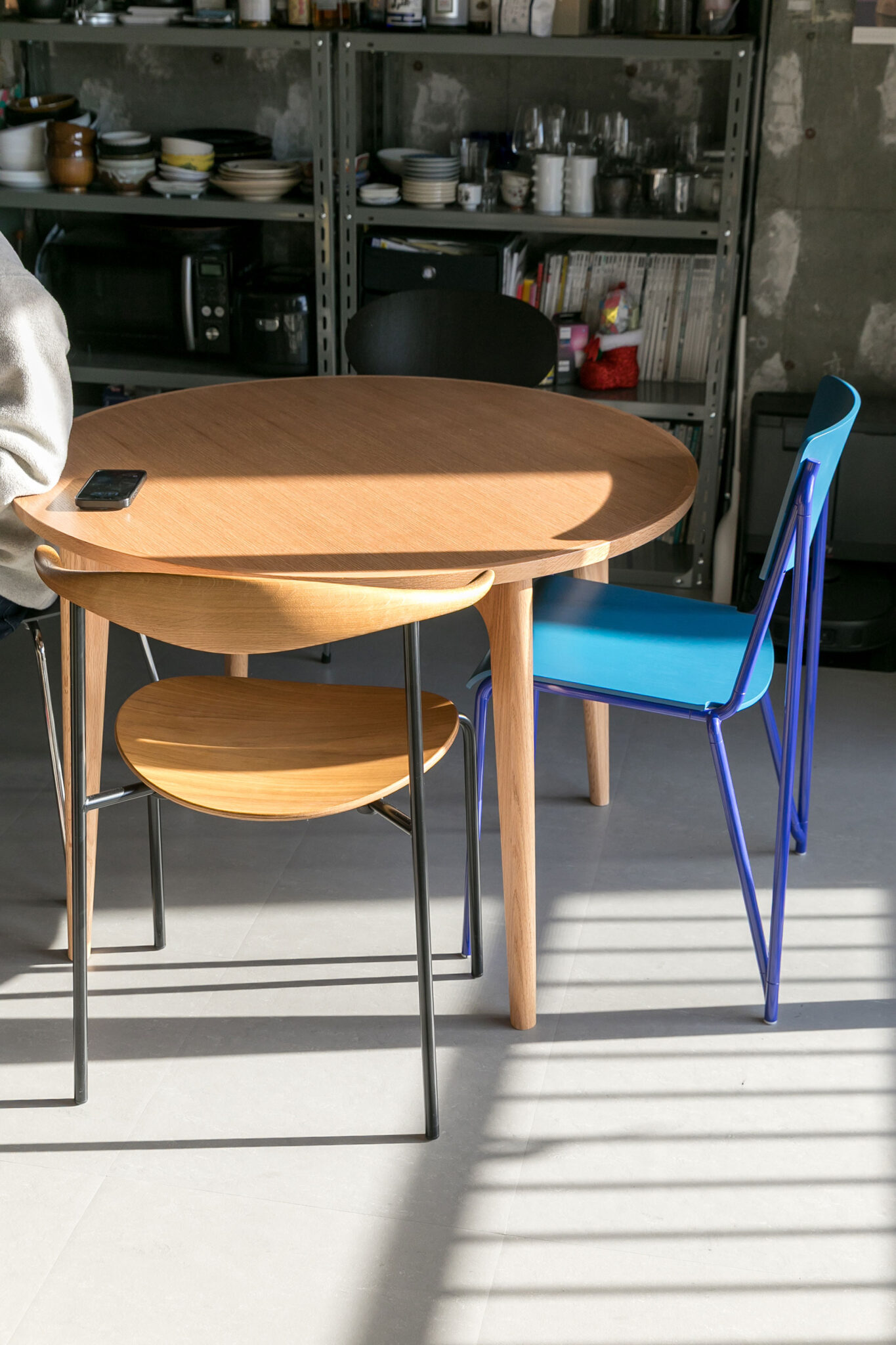 円形のダイニングテーブルはマルニ木工。「天板の縁どりが気に入りました」。ブルーのチェアはHAY、手前はハンス・J・ウェグナー。
