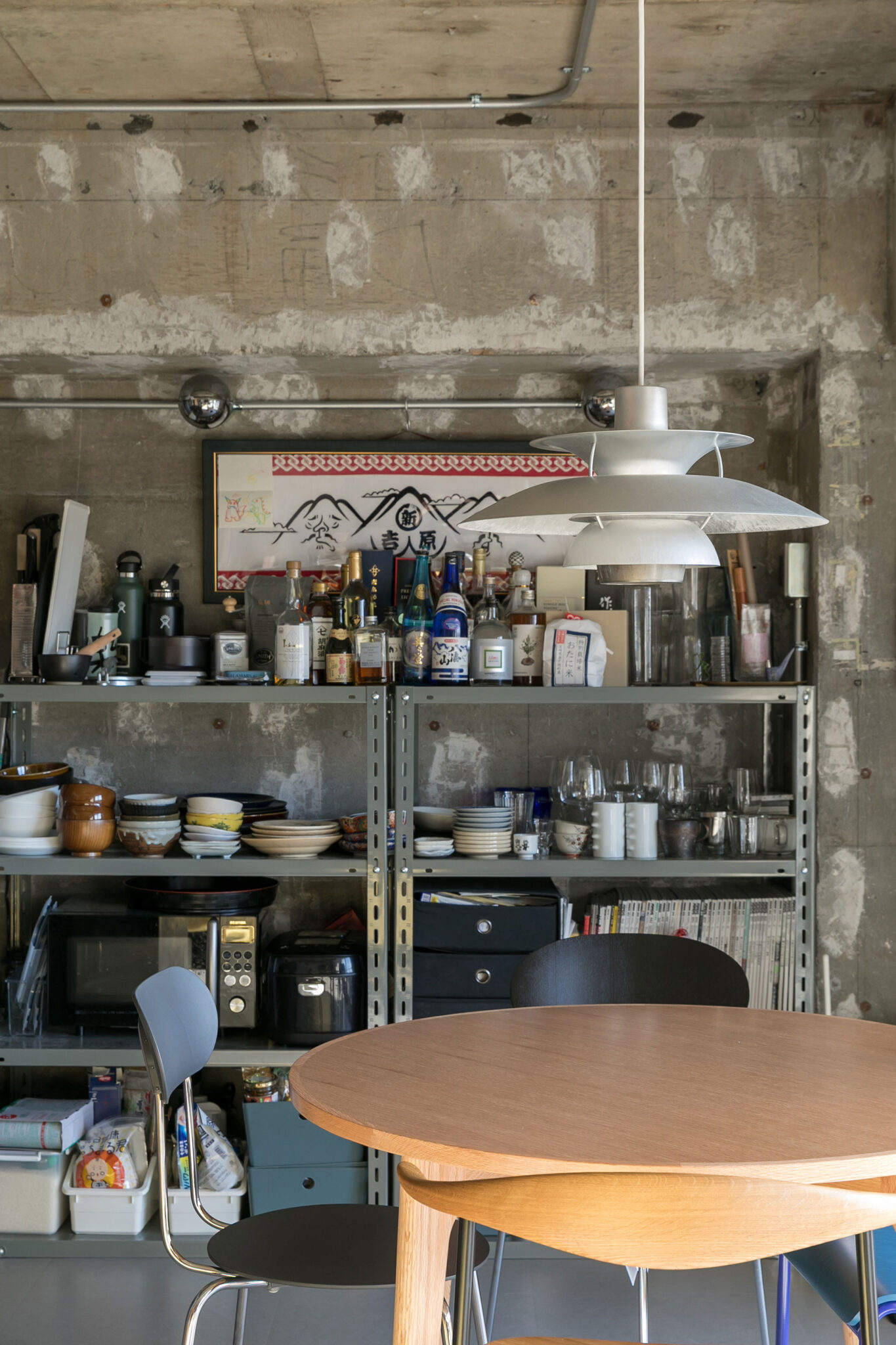 素地が露になったルイス・ポールセンのペンダントライトは、公式リリースのレアなモデル。躯体現しの天井や梁と呼応する、マットな質感が空間に馴染む。