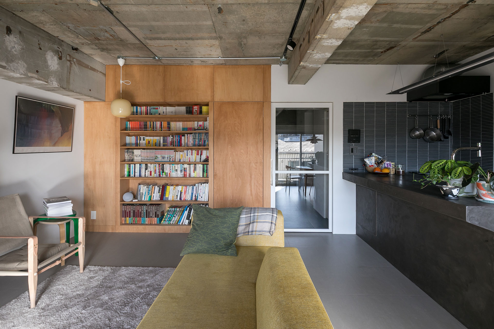 モノトーンの空間に浮かぶ、木の”箱”。本棚の横が扉になっていて、中がプライベートな寝室とクローゼットになっている。