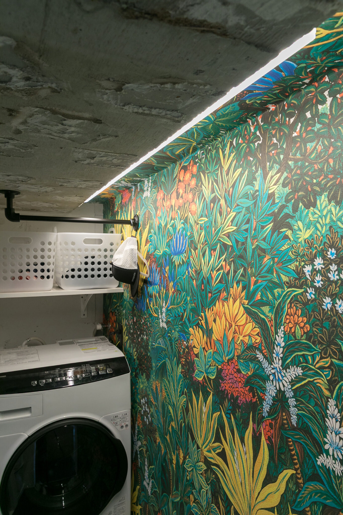 DIYで貼った壁紙。天井近くの段差を活かして照明を仕込んだ。