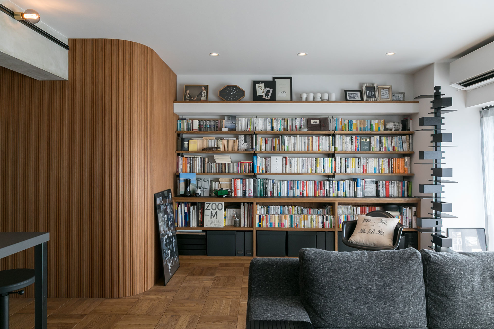 壁一面の造作本棚が、程よい差し色を加える。大量の本を入れることを想定し、棚板は厚め。