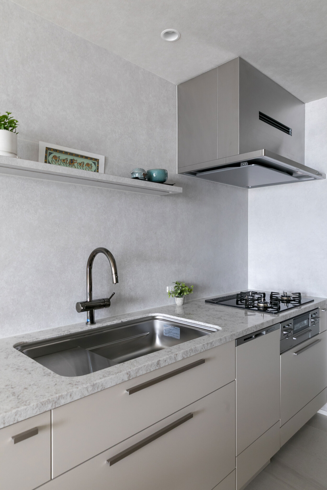 キッチンは既存の吊り戸棚を取払い、壁面をパネル張りに。キャビネットにはベージュのシートを貼って仕上げた。