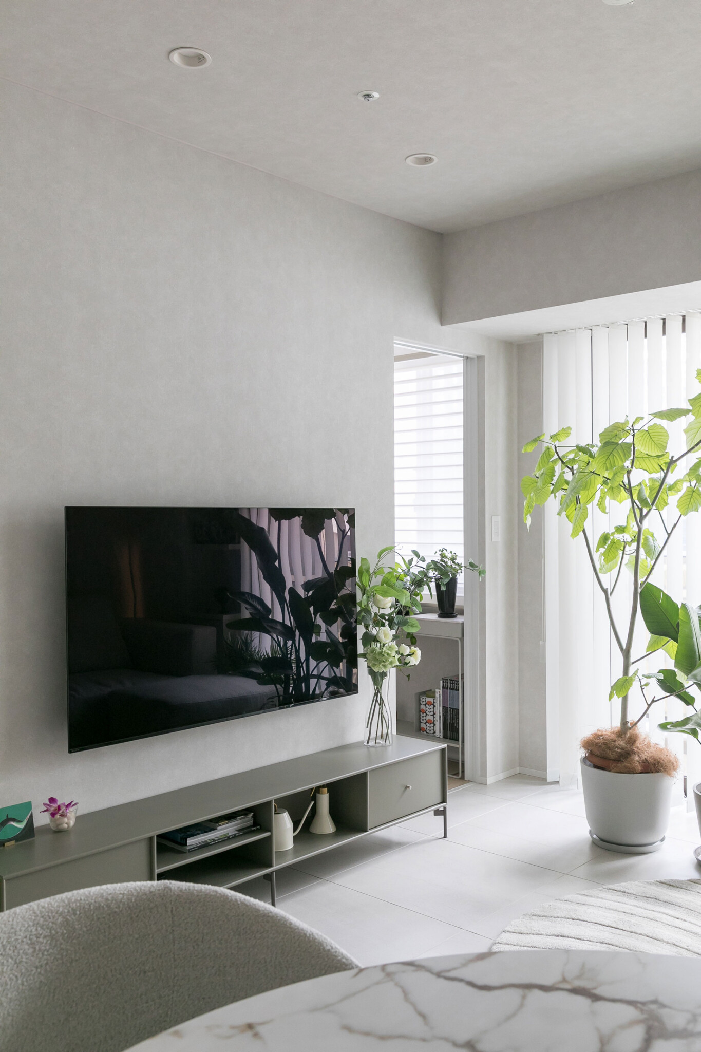 書斎への扉を開けたところ。テレビは壁付けにして、すっきりと。カーキ色のテレビボードは、アクタスで購入したもの。