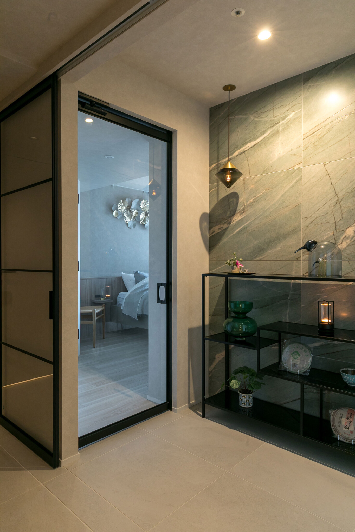 廊下からホールと寝室を見る。寝室の床はフローリングとし、素材の切り替えによって空間に区切りをもたせている。