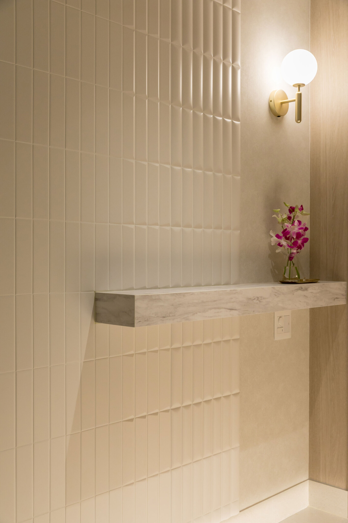 玄関の壁面のタイルは、表面がフラットなものから波打つものまで３種類を張り分け、空間に豊かな表情を生み出している。3種類のタイルは平田タイルのもの。