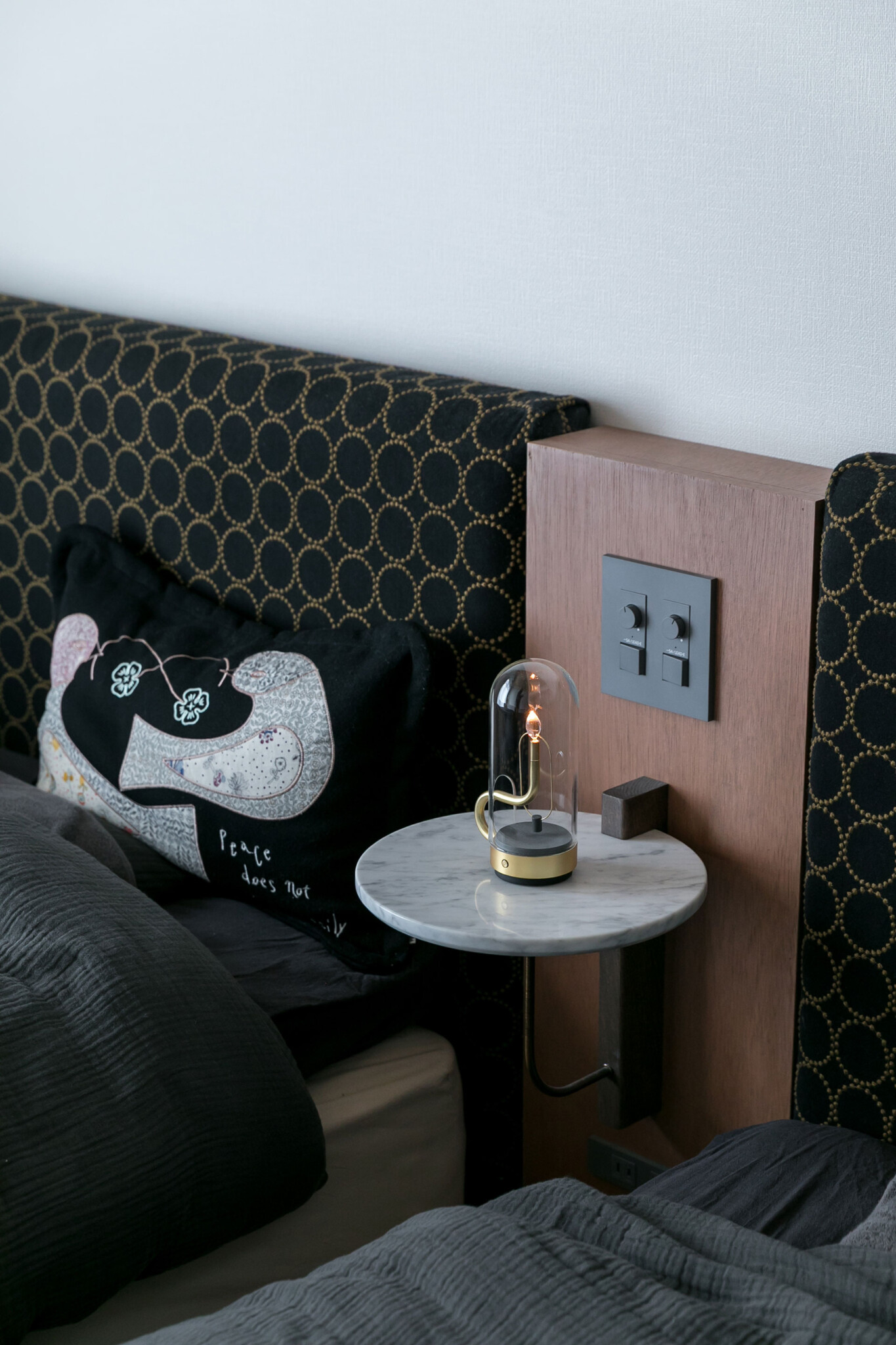 ベッドサイドには、アンビエンテックのポータブル照明hymn。炎を思わせるゆらぎが、心をやわらかくほぐしてくれる。