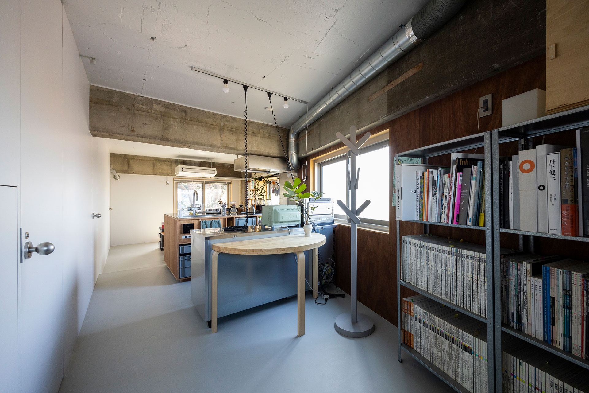 玄関を上がると、リビングまで視界が開ける。床の長尺塩ビシートは、汚れに強く掃除もしやすい。色の印象を揃えるため、天井は壁よりもワントーン明るいグレーで塗装した。