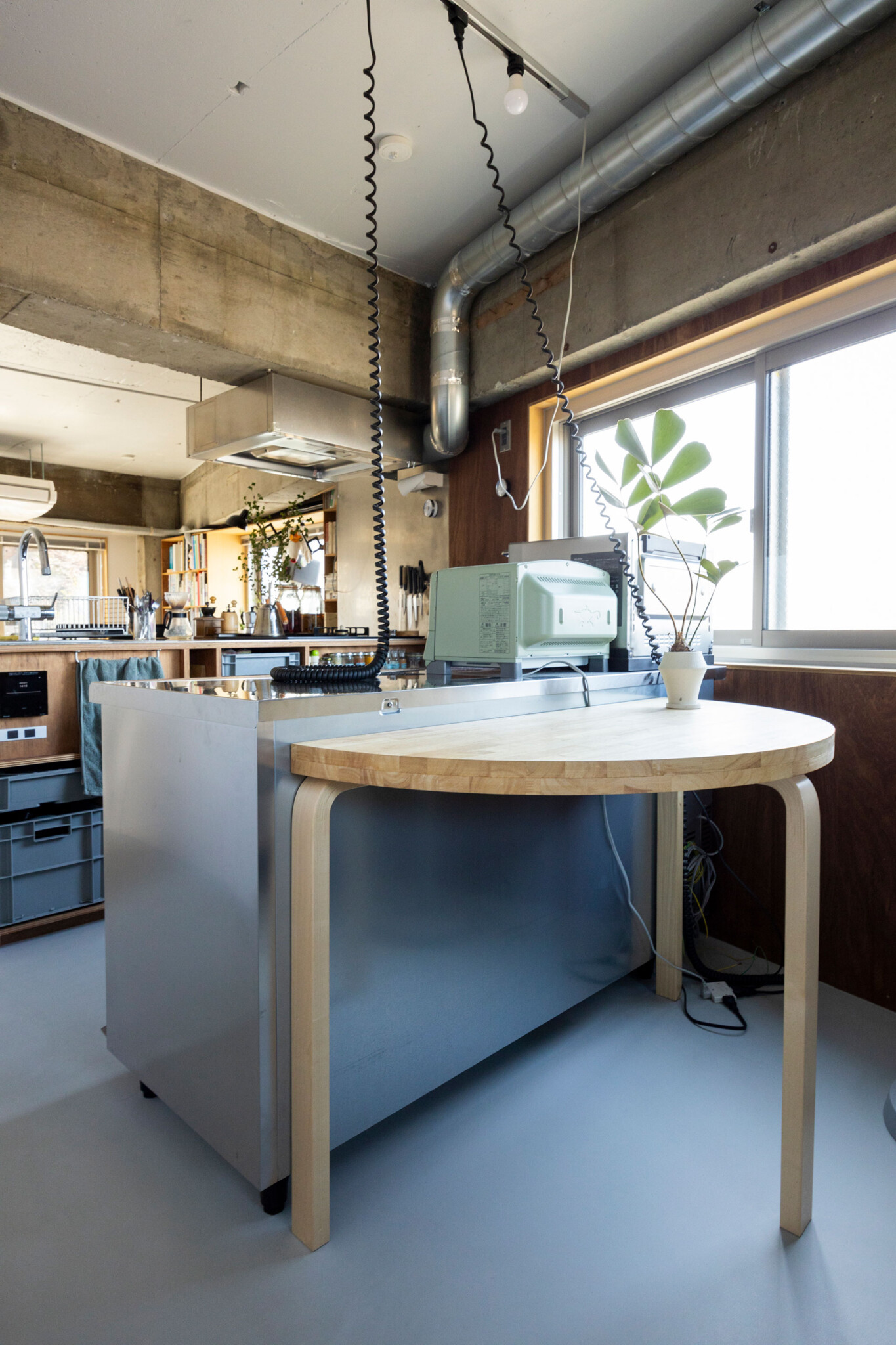 半円形のテーブルは、Artekの脚に廃材の板で作った天板を載せてDIYしたもの。