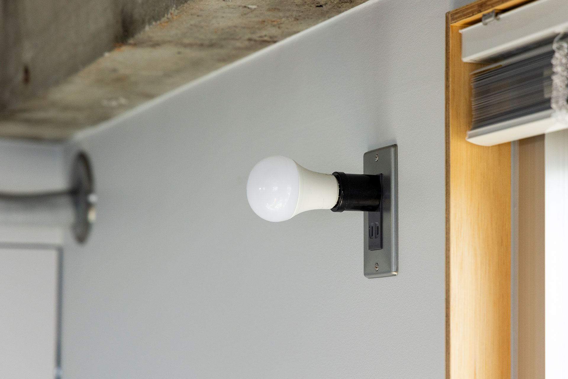 Amazonで購入したソケットを電球に取り付け、コンセントに差し込んだだけの照明。パネルを高い位置に設置した。