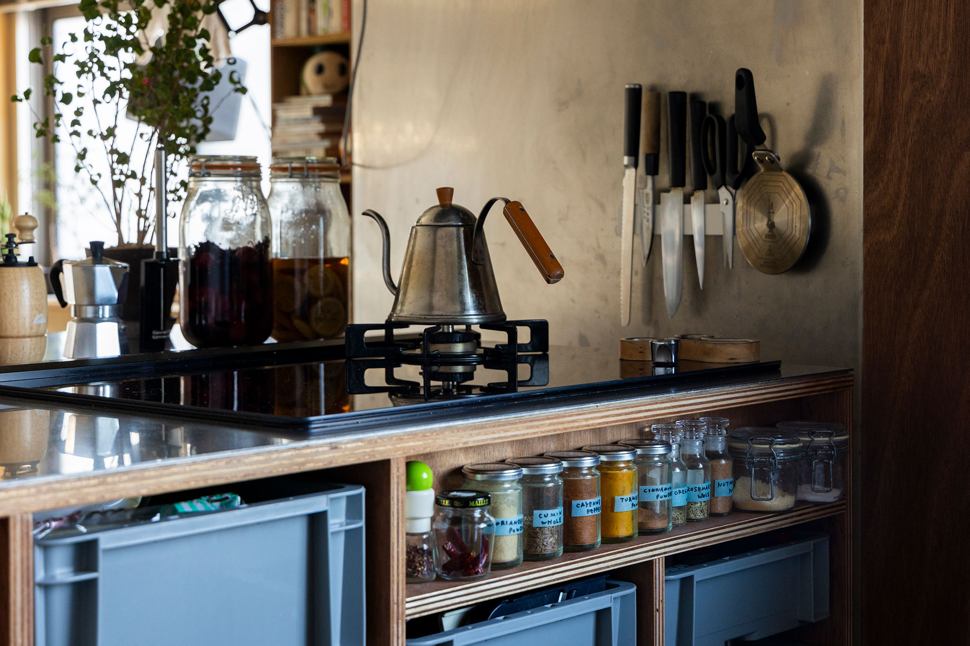 よく使うスパイスを収めるラックをコンロ下に。キッチンパネルには磁石のステンレスを使用。梅干し、レモン酒なども自家製で。