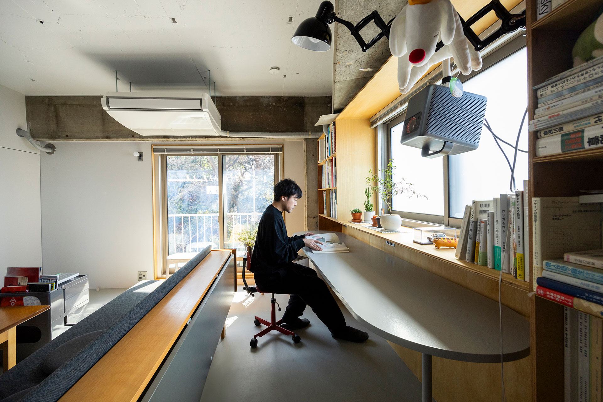 『リノべる』デザイナーの加藤拓郎さん。明るい窓際でリモートワークを行うことも。