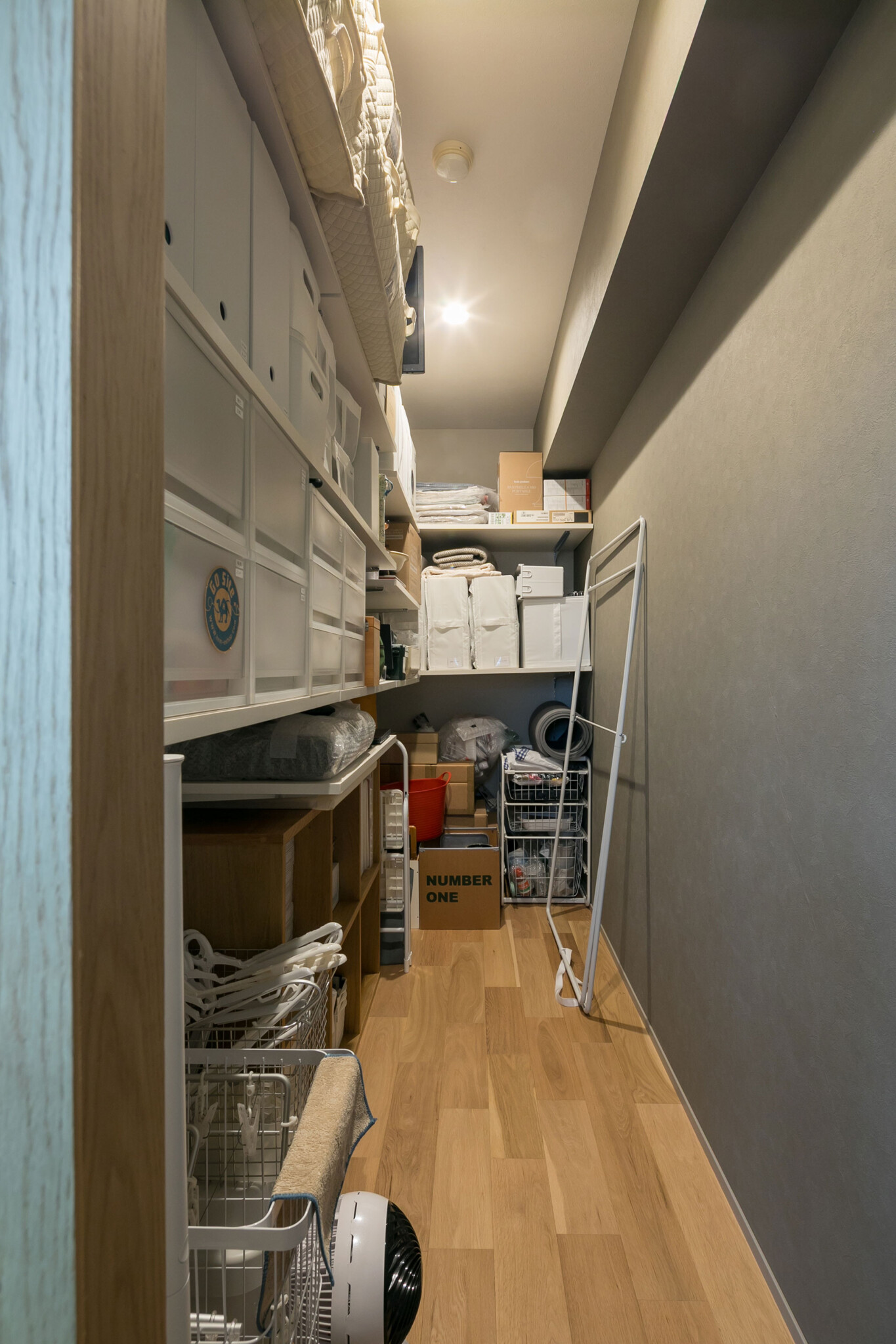 壁裏の収納スペース。アイロンや掃除機など日常使いのものから、布団などの大物まで収納されている。ウォークインになっており、使い勝手が良いそう。