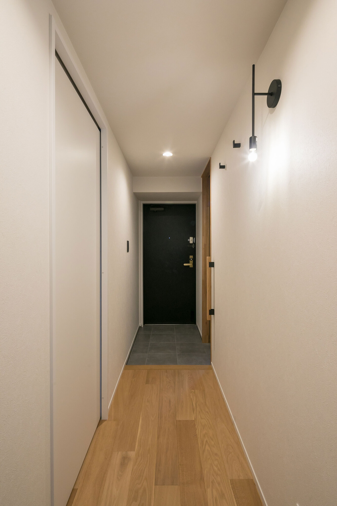 キッチンから玄関を見る。左手に夫妻の寝室が、右手にウォークスルークローゼットと土間収納がある。