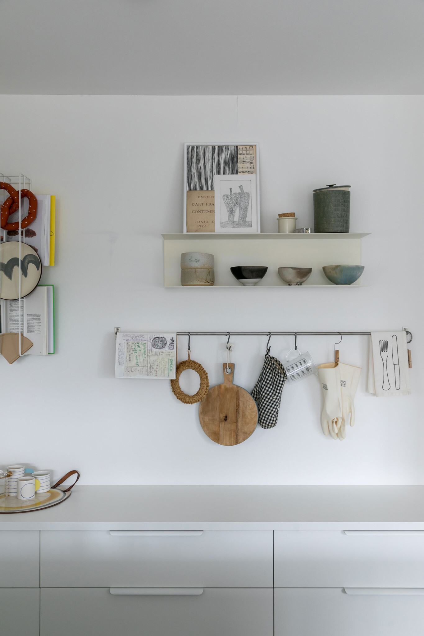 アートと器を壁に飾る。右の壁付けのラックはIKEA。左のワイヤーラックは「By Trico」。