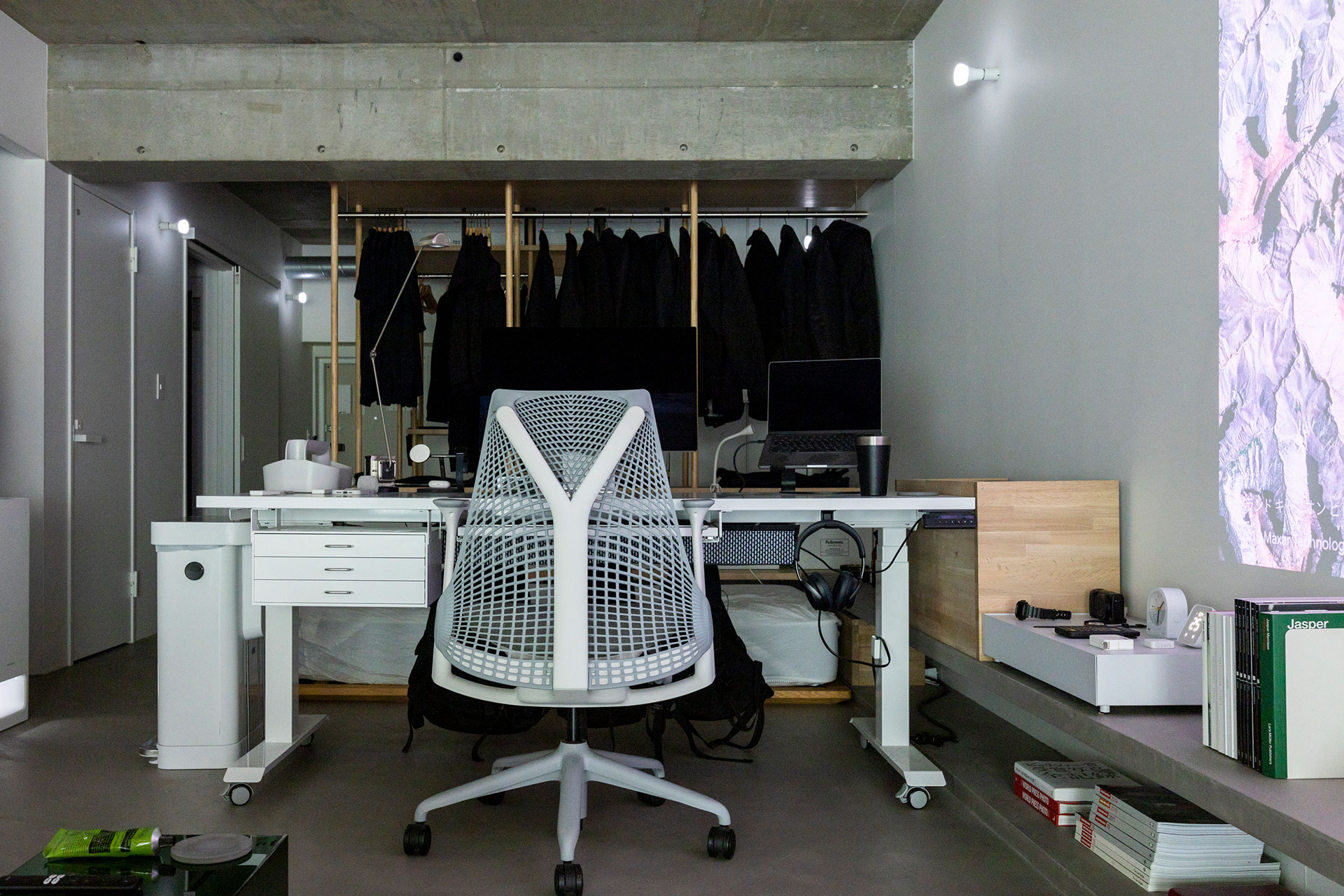 在宅ワーク時に使うワークスペース。机は天板が電動で昇降する『PREDUCTS DESK』。ベッドスペースとの仕切りにもなっている。