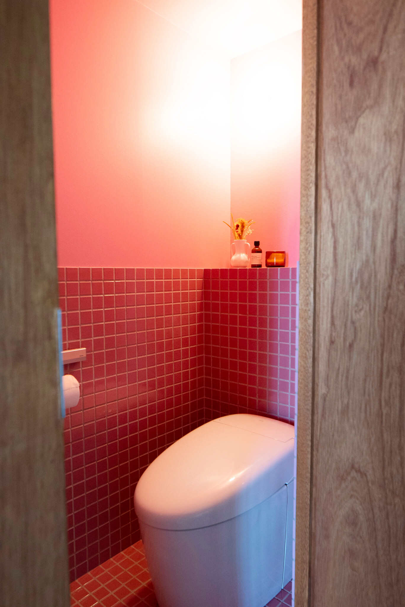 唯一といっていい扉があるトイレはピンクの壁とモザイクタイルで遊んだ。「カフェでもトイレがかわいいとときめくので、思い切った色と素材を選びました」。