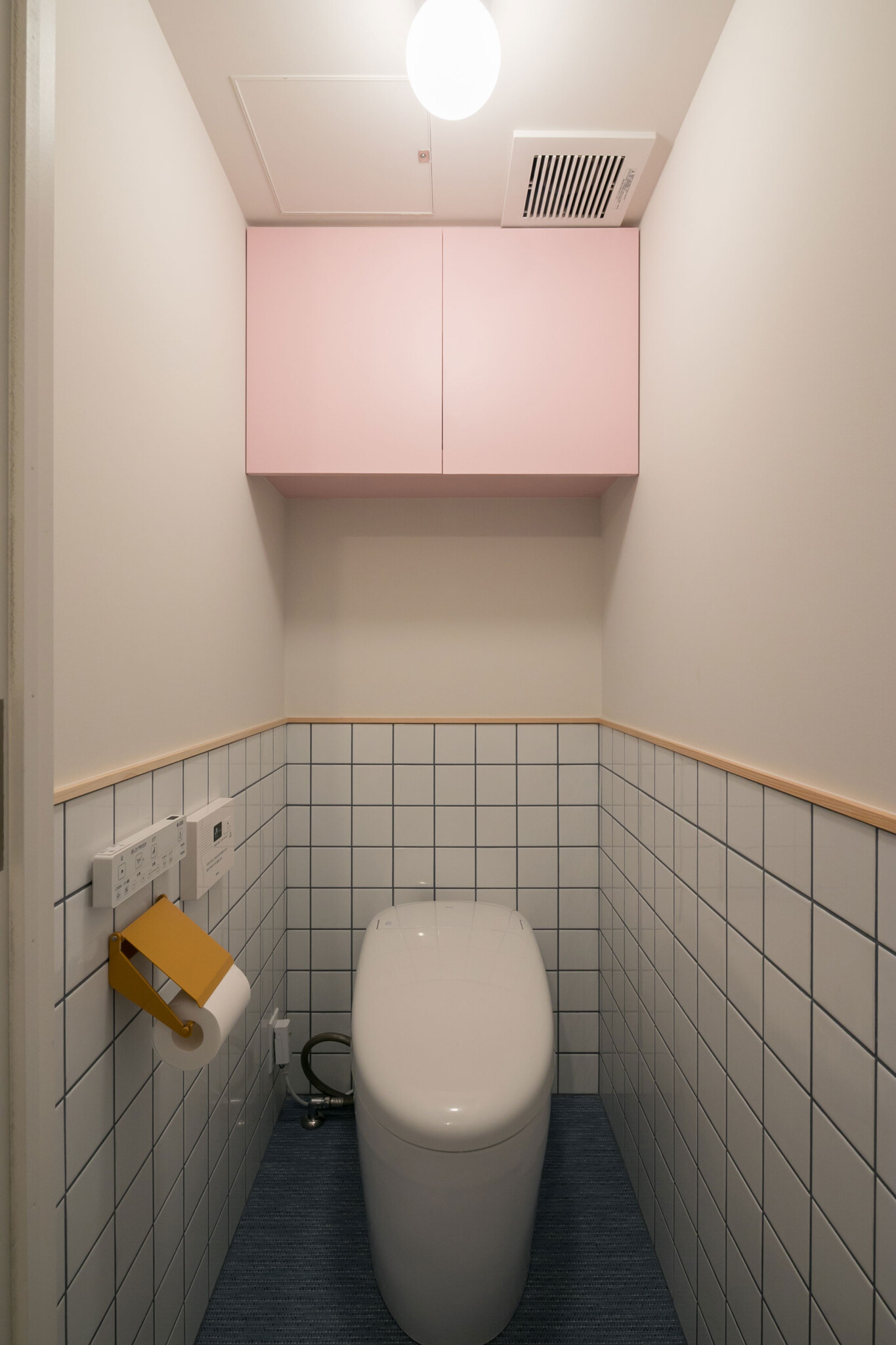 吊戸棚はピンク、トイレットペーパーホルダーはイエロー。はなちゃんが選んだ、自由な発想の色の組み合わせが素敵。