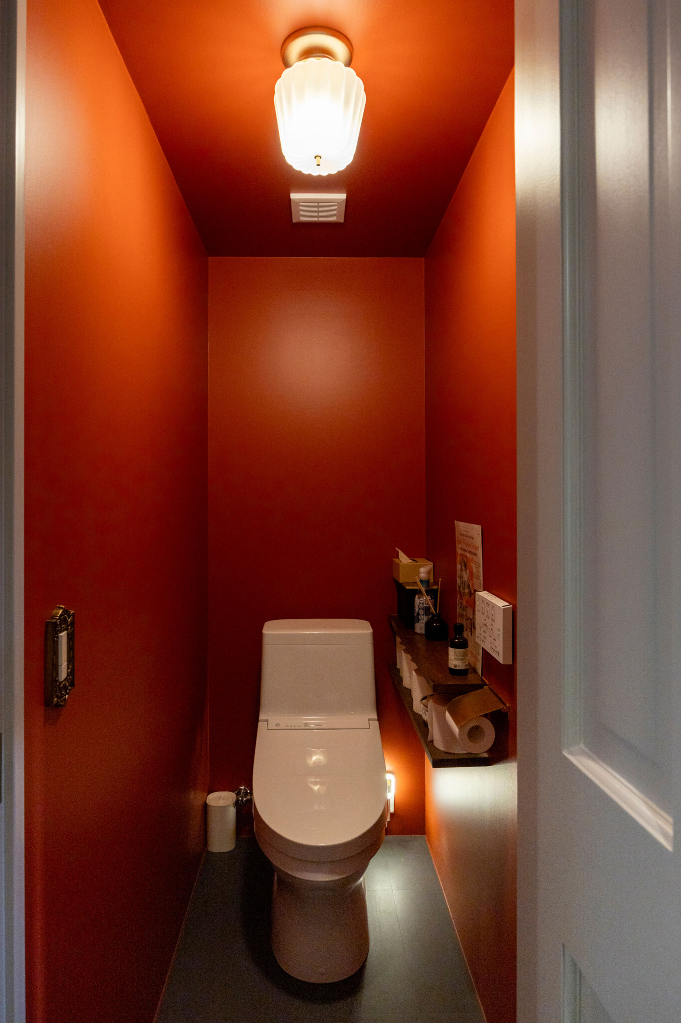 「トイレこそ遊んでいい」と、赤で冒険。カヌレ型の照明、ネットで見つけて自ら付け替えたスイッチフレームなど、ここもワクワクできる空間のひとつとして完成。