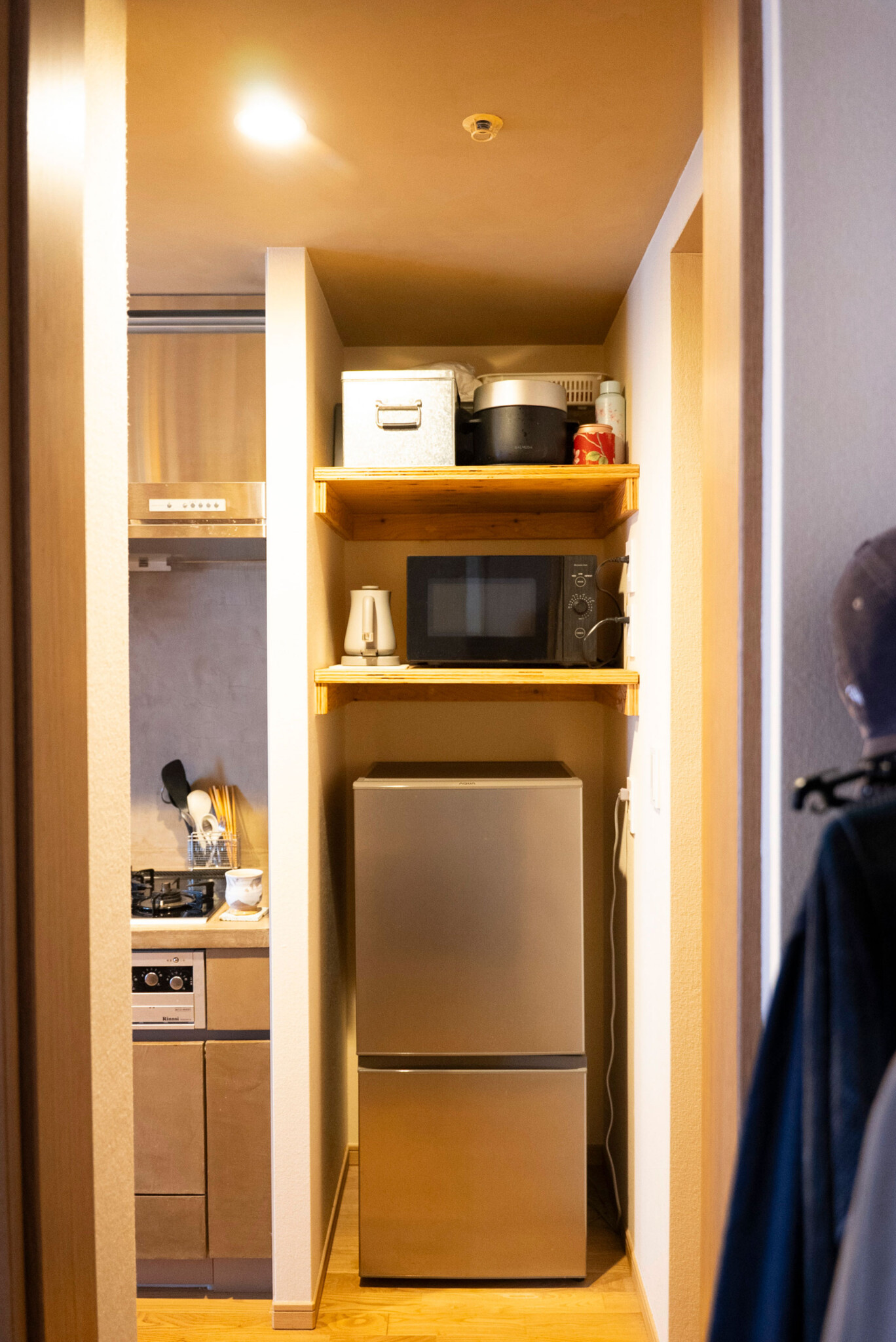 キッチン横は大型冷蔵庫用のスペースだったが、小さめの冷蔵庫を選択。上部に棚を設けて自身の暮らしと使い勝手に合うスタイルに